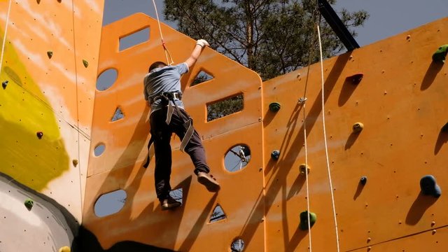 Free climber boy climbing On Practical Wall
