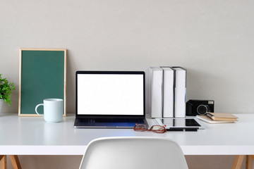 Office creative desk with blank screen laptop and supplies. Mockup laptop.