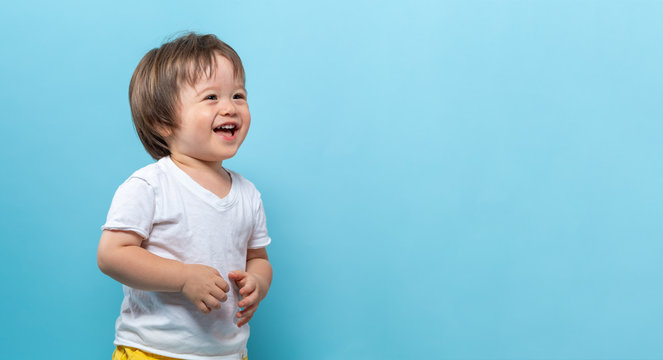 Toddler boy smiling on a bright blue background