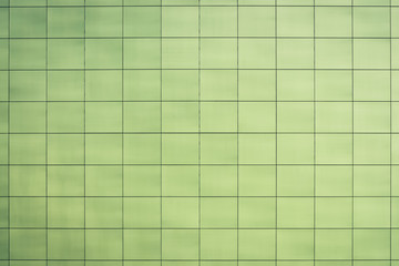Beautiful greenish toilet, kitchen, bathroom - smooth square tiles close-up. Light green texture of wall, floor, ceiling closely with copy space. Easy green sleek facing tile of building wall.