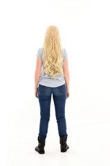 full length portrait of blonde girl wearing casual blue shirt and jeans, standing pose with back to the camera. isolated on white studio background.