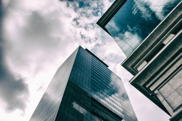 White clouds are reflected in the windows of business buildings made of glass.