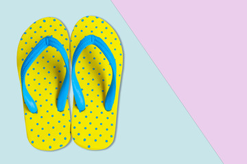 Yellow sandals on pink and blue color background, flat lay photo