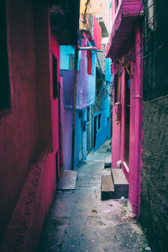 An alley with houses in Heliopolis, the biggest favela in San Paulo, Brazil, colored in blue, pink, purple and grey.