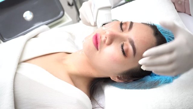 Young Asian woman getting IPL and laser treatment by beautician at beauty clinic