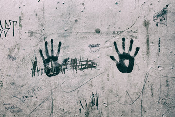 Right and Left black hand print marks on a ruined dirty white wall. Wallpaper.