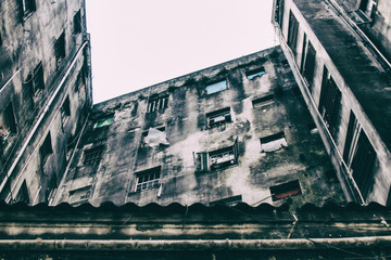 An abandoned building now occupied by social housing movement with white sky on the background. Internal view of the complex in C shape of this timeworn construction. San Paolo, Brazil, South America.
