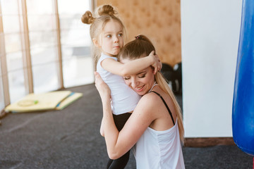 Mom hugs her little daughter