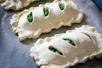 Buns of puff pastry with sorrel close-up. Homemade cakes with greens during cooking