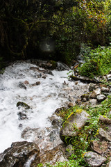Naklejka na ściany i meble Surrounded by wild and ancient forest a waterfall on the stone paved path Inca Trail on the way to Machu Picchu, Peru.