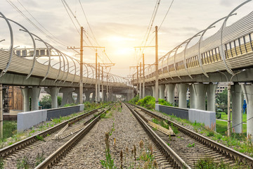 Fototapeta premium View of railway tracks and highway bridges at sunset.