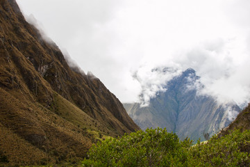 From the wild jungle, the Andes mountains covered by clouds and fog on the Inca Trail hiking paved path to Machu Picchu. Peru. South America. No people.