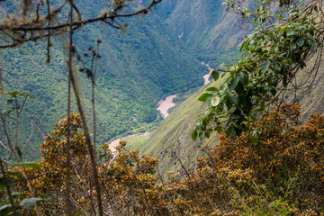 Fototapeta na wymiar A red water river in the valley surrounded by the wild nature of the Andes mountains seen from the Inca Trail. Peru. South America. No people.