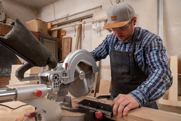 carpenter work with circular saw for cutting boards, the man sawed bars, construction and home...