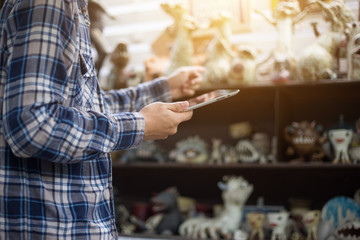 Businessman with touchscreen tablet checking inventory in stock room. Store house inspection