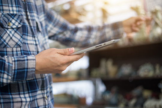 Businessman With Touchscreen Tablet Checking Inventory In Stock Room. Store House Inspection