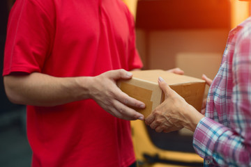 Womans hands accepting delivery box from deliveryman. Close up shot of man giving tan cardboard box to female client.
