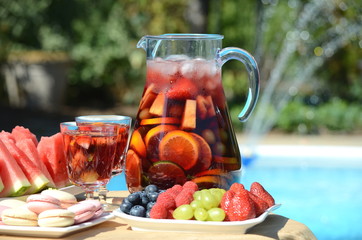 Pool party with sangria pitcher, fruit cocktails and refreshments by the swimming pool. Summer...