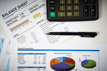 balance sheets with calculator and pen