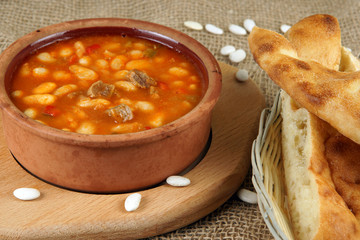Bean soup in clay country crockery on a table with lavash