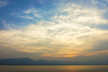 Naklejka na ściany i meble landscape of clouds sky sunset over lake with mountains