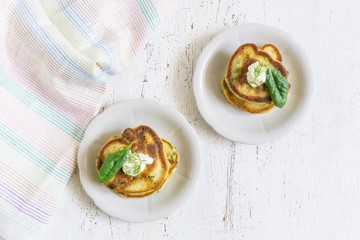 traditional spinach fritters with yoghurt cream on a light background