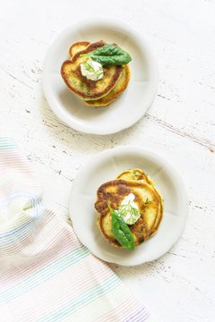 traditional spinach fritters with yoghurt cream on a light background