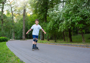 Obraz premium A teenager boy is rollerblading in the park.