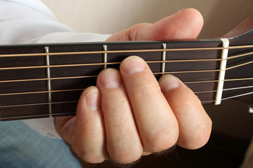 Obraz premium Hands of a musician playing classical acoustic guitar
