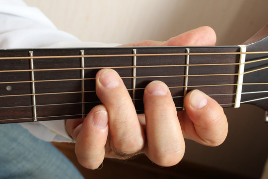 Hands of a musician playing classical acoustic guitar