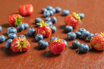 Strawberries and blueberries on a wooden table