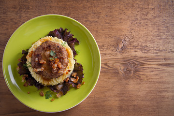 Delicious burger or patty with mashed potato on lettuce, served with salty caramelized onion. overhead, horizontal