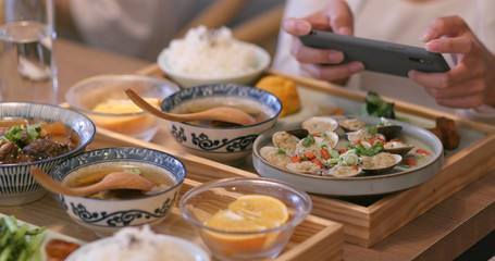 Woman taking photo on her dishes in Taiwanese restaurant