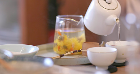 Obraz na płótnie Canvas Pouring tea to a cup in restaurant