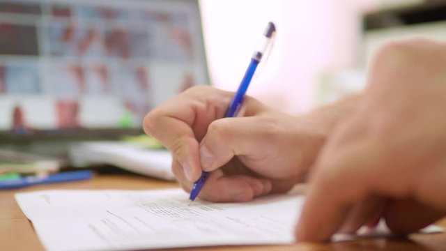 Close up shot of hands of the man who leaves his initials on the agreement. Senior signs a pen on the contract. Everyday office life
