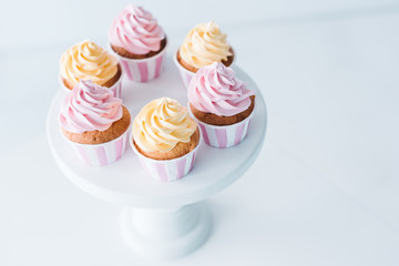 close up view of delicious cupcakes on stand at table