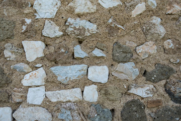 Beautiful wallpaper background of an antique wall made of square stone white bricks whit cement. No people.