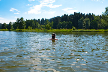 Young woman is swimming in Lake Rannasee in Bavaria