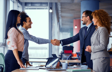 Multiethnic business teams at meeting room shaking hands. Handshake of two men. Toned concept.