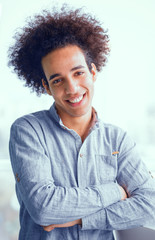 Portrait of young businessman in shirt with crossed arms. Smiling young male in casual shirt with stylish hair. Toned concept.