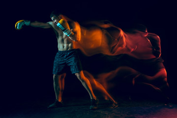Male boxer boxing in a dark studio