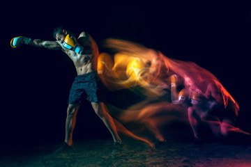 Male boxer boxing in a dark studio