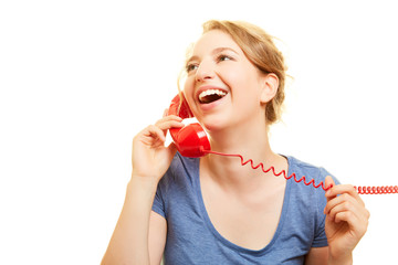 Junge Frau lacht beim Telefonieren am Telefon