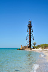Fototapeta na wymiar old lighthouse on the shore of the turquoise sea