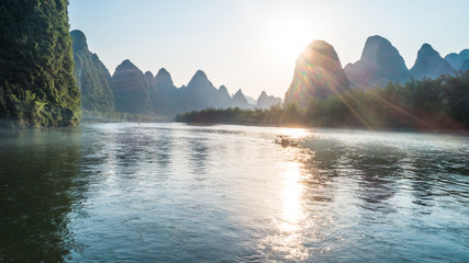 bamboo boat moving at Li River during sunset time - obrazy, fototapety, plakaty