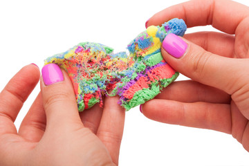 Close-up of a photo in the hands of kinetic sand on a white background