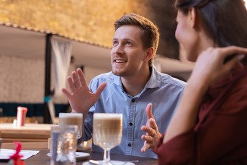 Amazing communication. Handsome blue-eyed man feeling really amazed while communicating with girlfriend