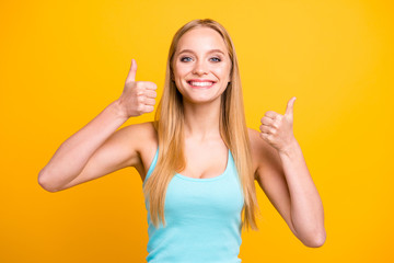 Portrait of young blond woman isolated on yellow background. Female model with toothy beaming smile...