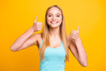 Portrait of young blond woman isolated on yellow background. Female model with toothy beaming smile...
