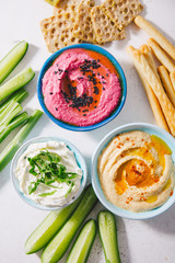 Fresh vegetarian dips in small bowls on table